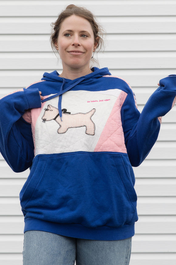 Person wearing a blue and pink hoodie with a dog design, upcycled in canada