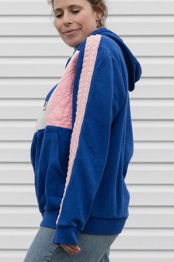 Person wearing a blue and pink hoodie with a dog design, upcycled in canada