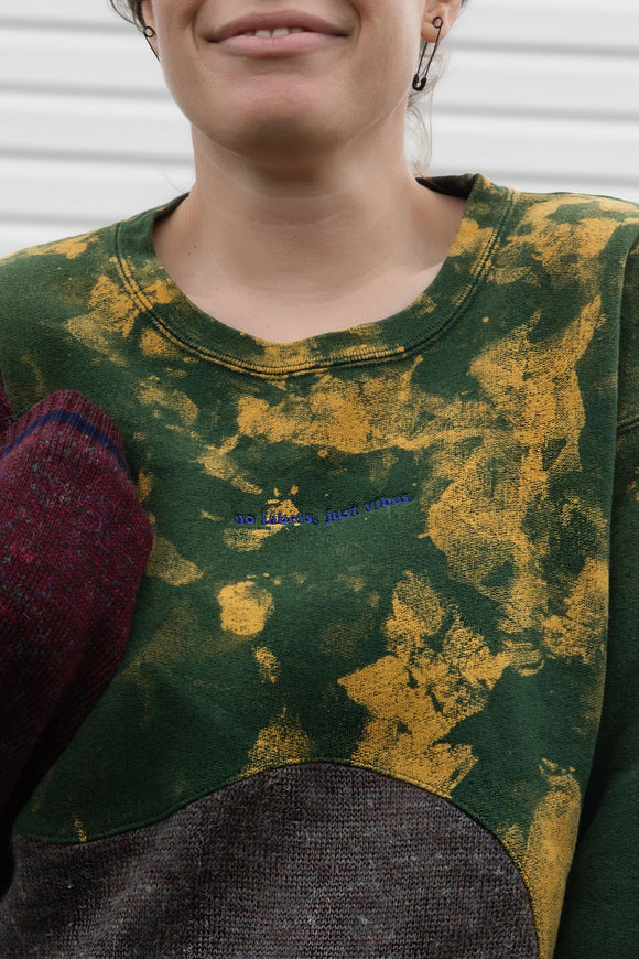 Person wearing a colorful sweater with a patterned design, upcycled in canada