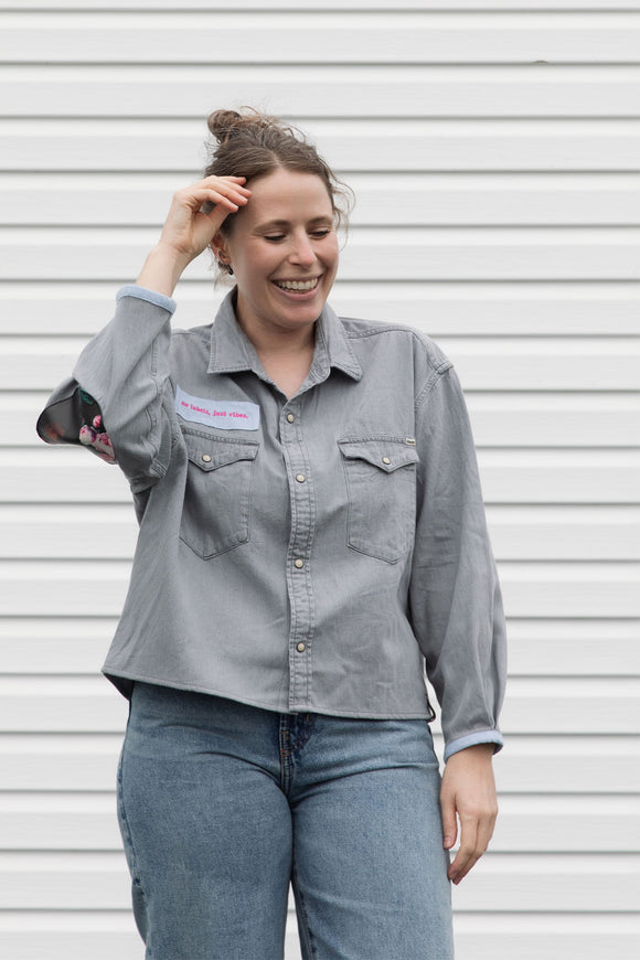 person wearing a silver button up shirt, upcycled with floral elbow patches, repurposed in canada