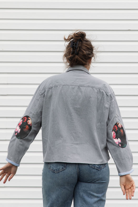 person wearing a silver button up shirt, upcycled with floral elbow patches, repurposed in canada