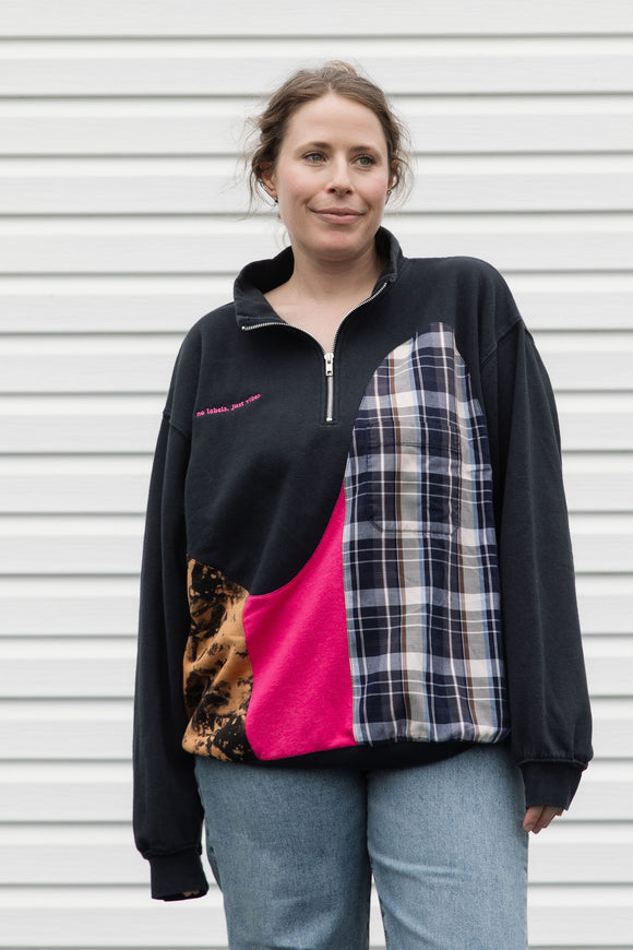 person wearing black half zip with lots of colour details and patterns, upcycled in canada