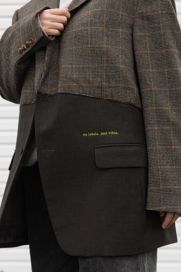 tweed blazer wtih green bottom, raw edges, upcycled in canada, detail shot of 'no labels, just vibes.' embroidery