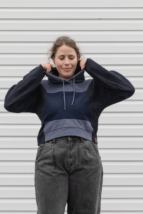 person is wearing a two tone navy hoodie, upcycled in canada
