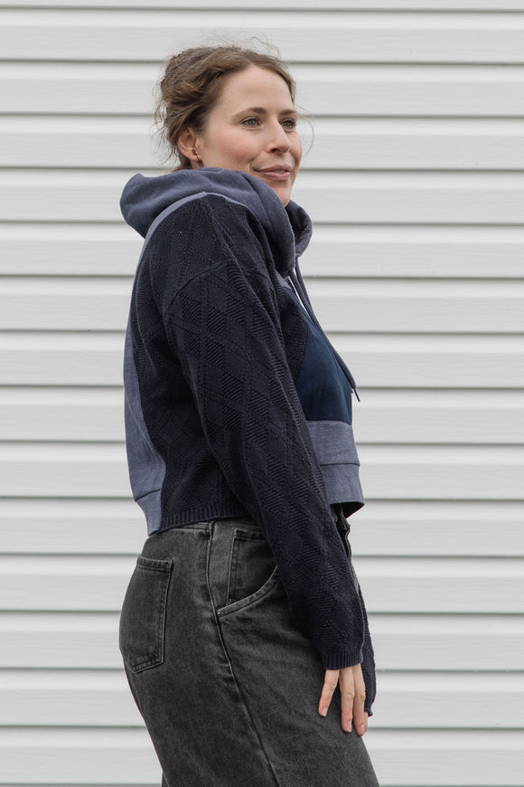 person is wearing a two tone navy hoodie, upcycled in canada