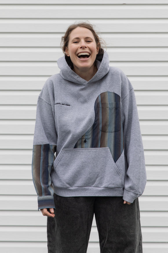 person wearing a grey hoodie with plaid inserts, upcycled in canada