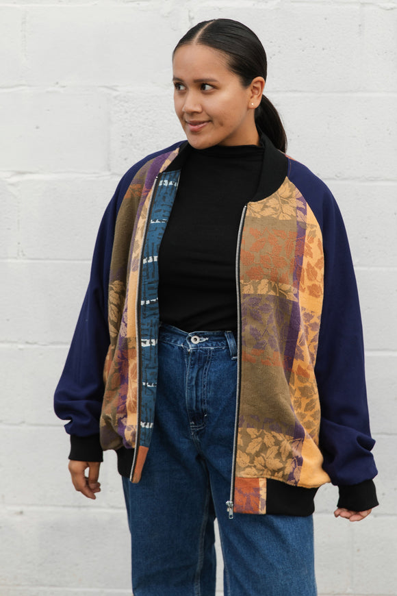 leafy table cloth upcycled into bomber jacket, orange, purrple and gold jacket with navy sleeves, handmade in canada