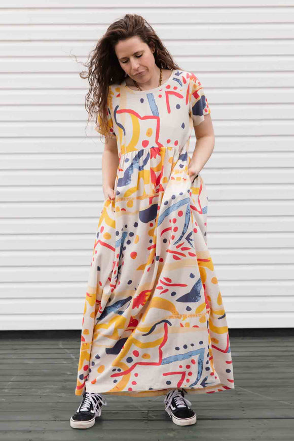 maxi dress with sleeve, pockets and a slight empire waist. dress has abstract colourful print. made in canada