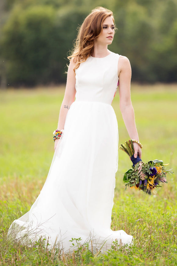 woman wearing an alternative wedding gown, white bodice with colourful floral lace in the back. cirnoline skirt, made in canada