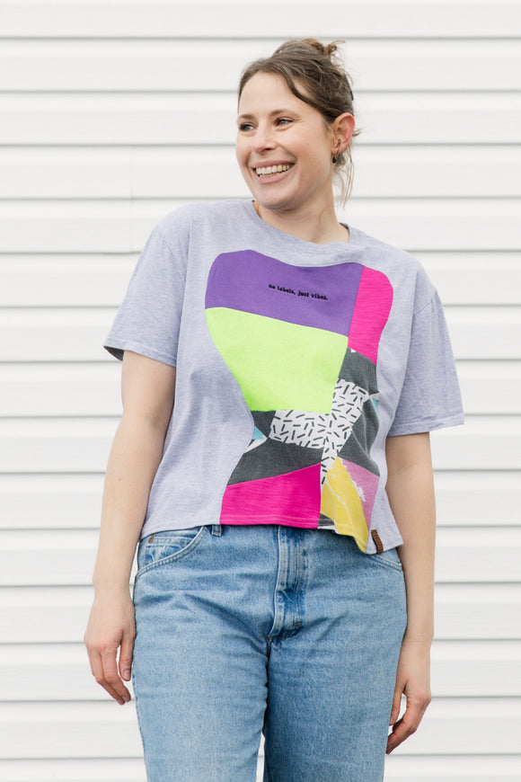 Person wearing a colorful graphic t-shirt with a plain background