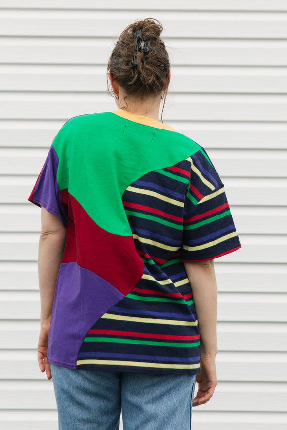 Person wearing a colorful, patterned shirt with a white background