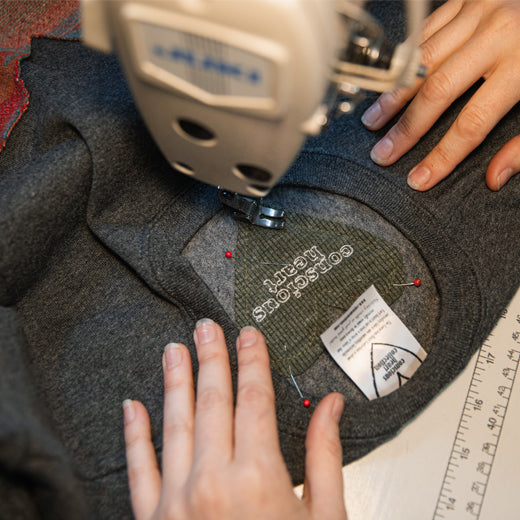 sewing a heart into a sweater with conscious heart embroidery