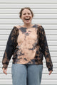 person wearing bleached sweater, upcycled in canada and featuring the 'no labels, just vibes.' embroidery