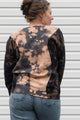 person wearing bleached sweater, upcycled in canada and featuring the 'no labels, just vibes.' embroidery