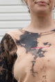 person wearing bleached sweater, upcycled in canada and featuring the 'no labels, just vibes.' embroidery
