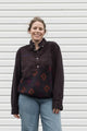 Person wearing a dark brown shirt with a patterned upcycled in canada