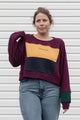 person wearing burgundy, gold, navy and green sweater, upcycled in canada