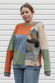 person wearing a one-of-a-kind patchwork sweater, featuring a knit cottage motif, upcycled in canada