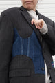 Person wearing a dark gray blazer with denim patch and visible embroidery, upcycled in canada
