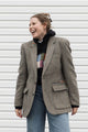 Person wearing a brown blazer with floral embroidery details upcycled in canada