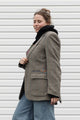 Person wearing a brown blazer with floral embroidery details upcycled in canada