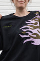 person wearing a black sweater with graphic flames in purple and green, upcycled in canada, detail shot of embroidery, no labels, just vibes.