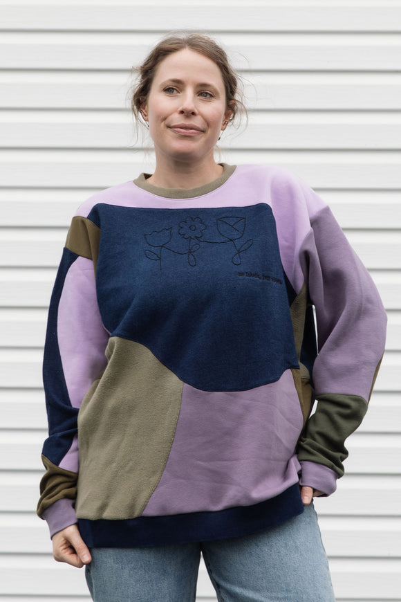 Woman wearing a colourful sweater with geometric design, upcycled in canada