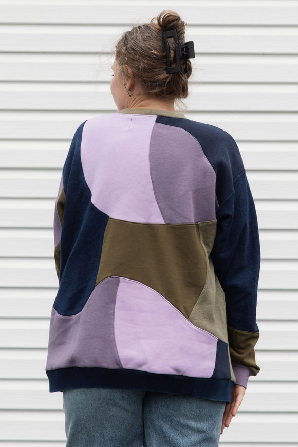 Woman wearing a colourful sweater with geometric design, upcycled in canada