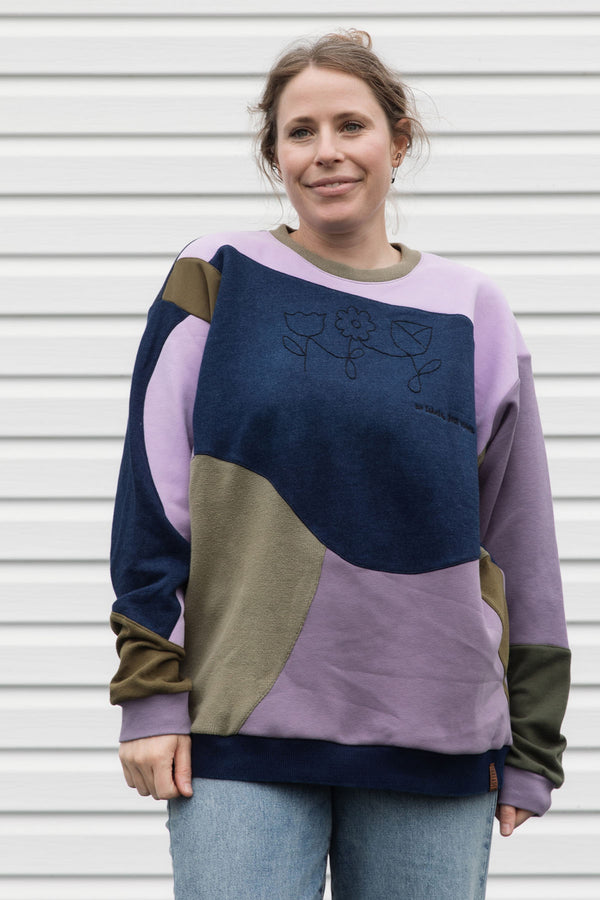 Woman wearing a colourful sweater with geometric design, upcycled in canada
