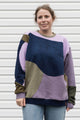 Woman wearing a colourful sweater with geometric design, upcycled in canada