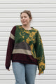 Person wearing a colorful sweater with a patterned design, upcycled in canada