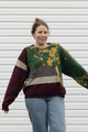 Person wearing a colorful sweater with a patterned design, upcycled in canada