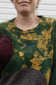 Person wearing a colorful sweater with a patterned design, upcycled in canada