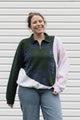 person wearing an upcycled sweater, featuring a green plaid knit sweater and pink tie dyed sweater sewn together, upcycled in canada