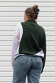 person wearing an upcycled sweater, featuring a green plaid knit sweater and pink tie dyed sweater sewn together, upcycled in canada