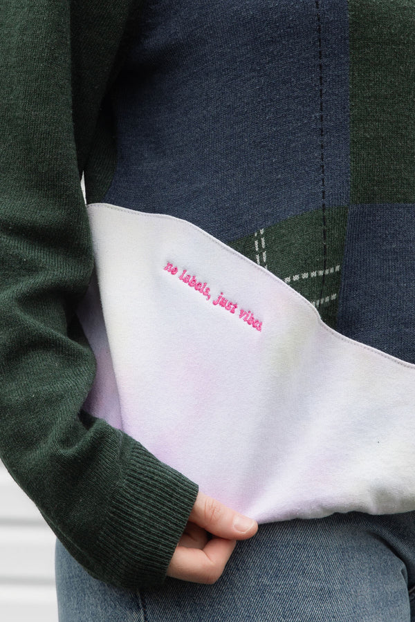 person wearing an upcycled sweater, featuring a green plaid knit sweater and pink tie dyed sweater sewn together, upcycled in canada