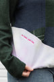 person wearing an upcycled sweater, featuring a green plaid knit sweater and pink tie dyed sweater sewn together, upcycled in canada