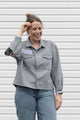 person wearing a silver button up shirt, upcycled with floral elbow patches, repurposed in canada
