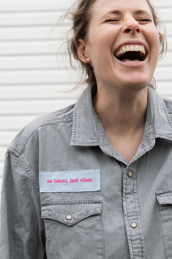 person wearing a silver button up shirt, upcycled with floral elbow patches, repurposed in canada