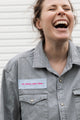 person wearing a silver button up shirt, upcycled with floral elbow patches, repurposed in canada