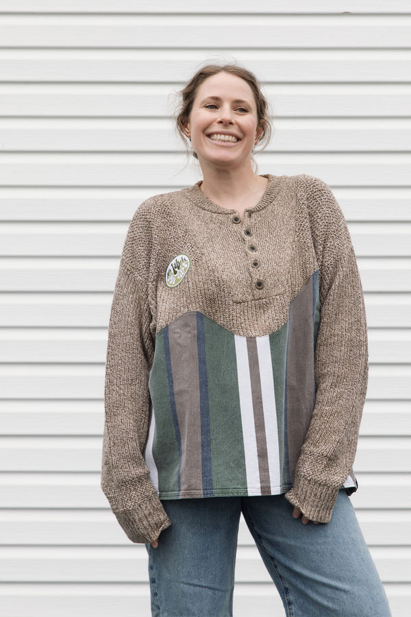 person wearing oversized brown knit with striped bottom, upcycled in canada