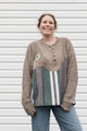 person wearing oversized brown knit with striped bottom, upcycled in canada