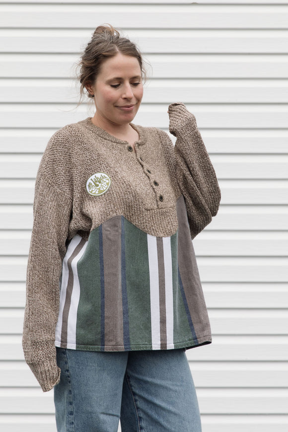 person wearing oversized brown knit with striped bottom, upcycled in canada