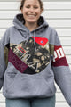 Person wearing a gray hoodie with colorful brand logos, upcycled in canada