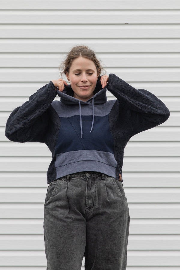 person is wearing a two tone navy hoodie, upcycled in canada