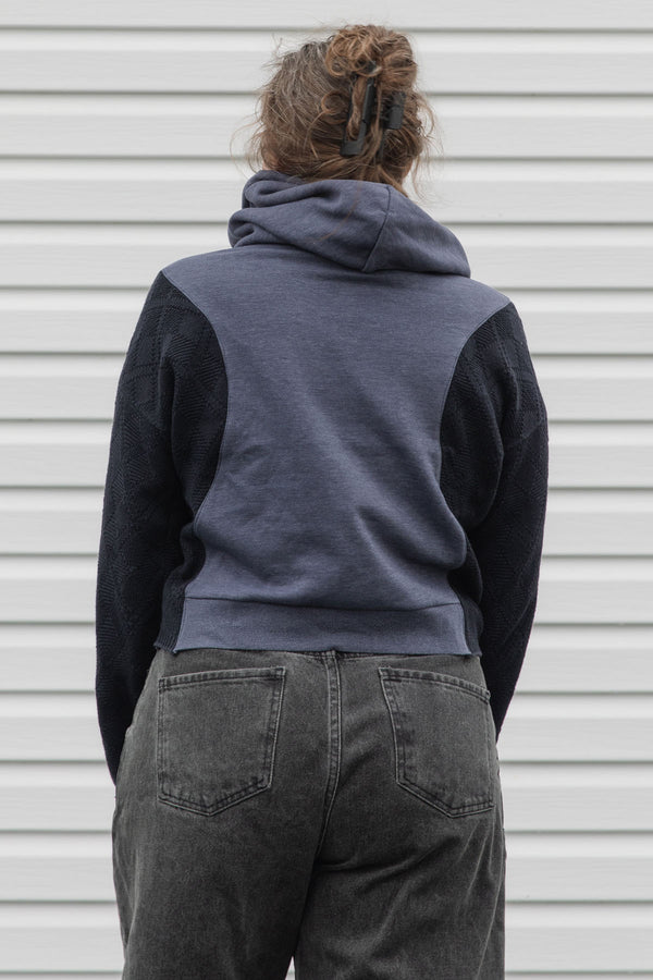 person is wearing a two tone navy hoodie, upcycled in canada