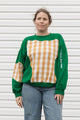 Person wearing a green and plaid sweater, upcycled in canada