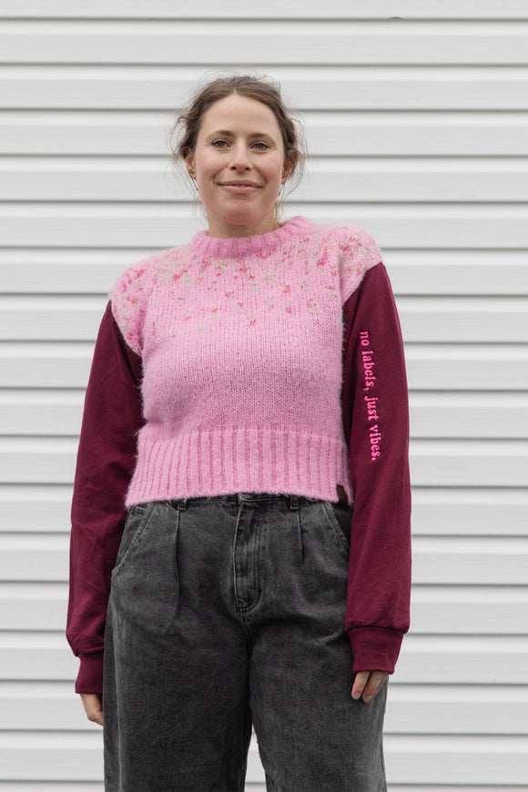 person wearing a pink knit sweater with burgundy sleeves, upcycled in canada