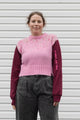 person wearing a pink knit sweater with burgundy sleeves, upcycled in canada