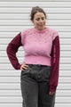person wearing a pink knit sweater with burgundy sleeves, upcycled in canada